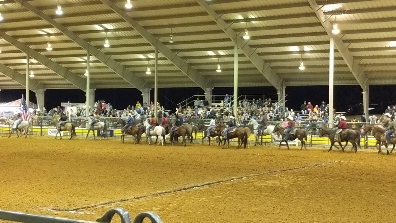 Beth and Cooper carrying the Red Sponsor Flag during opening of the rodeo