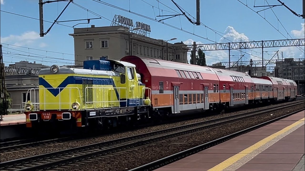 Żółto-niebieska lokomotywa SU42-518 „Polsat” pociąg Chojnice-Hel na stacji kolejowej Gdynia Główna
