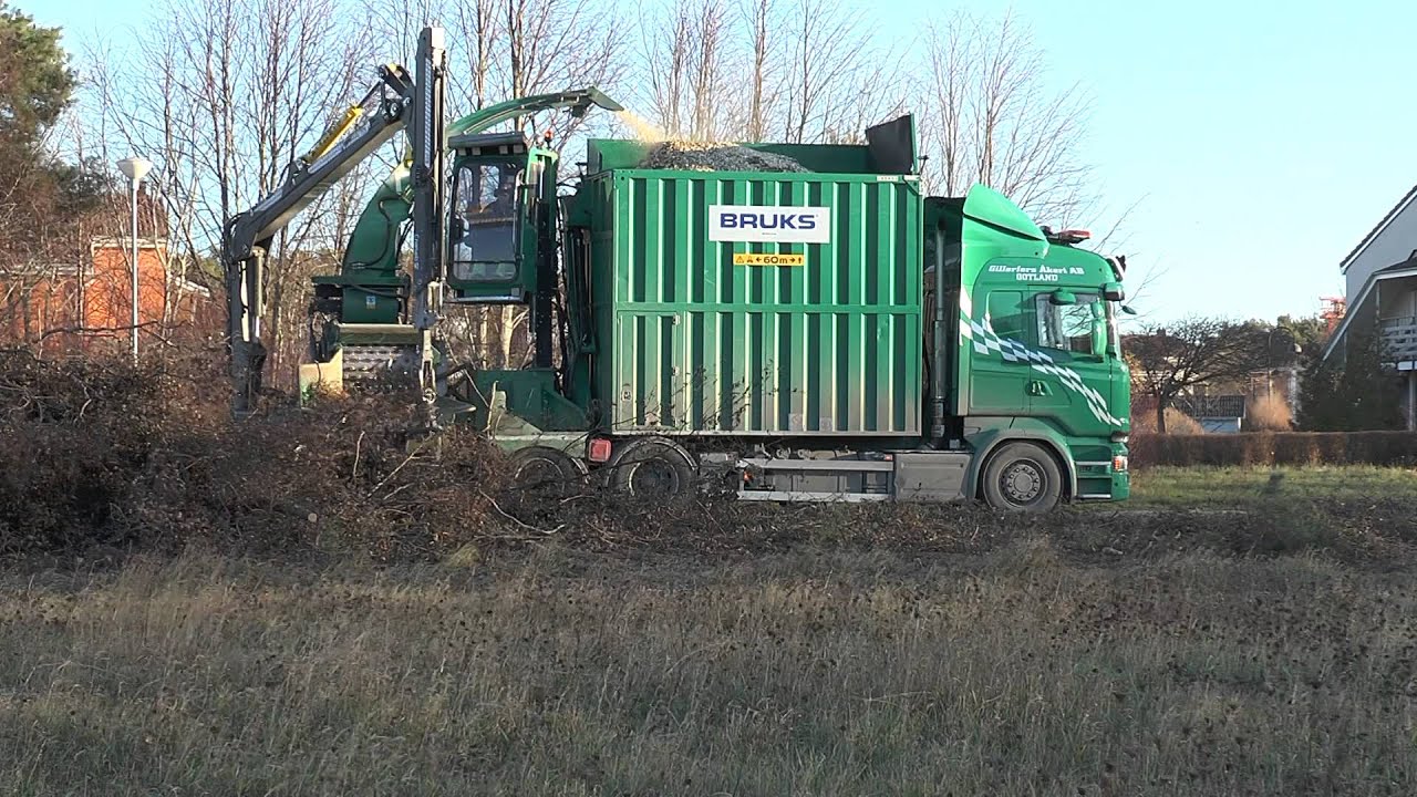 Scania R730 V8 operates a Bruks chipper to be a heat works outside Visby