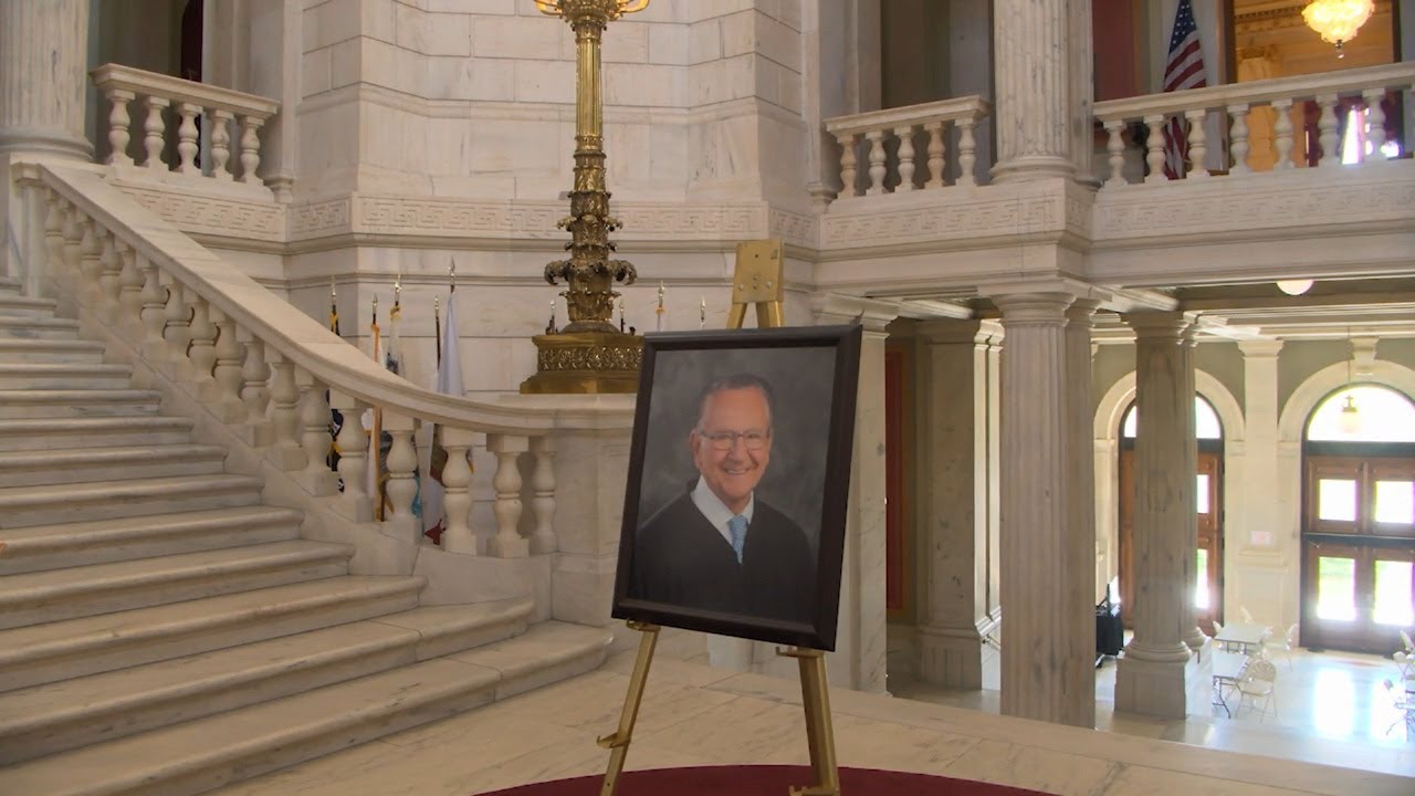 State house rotunda displaying Caprio portrait, public condolence book