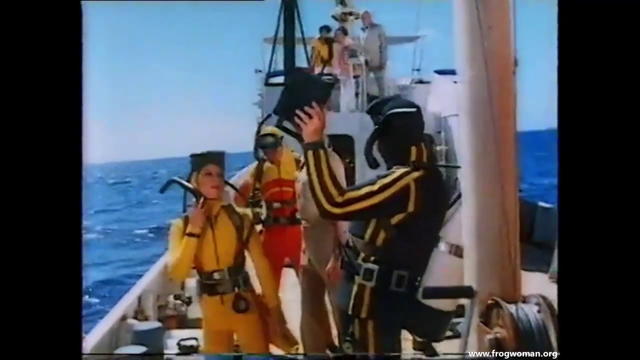 One female diver and 2 guys explore the outer hull off a sunken submarine [earlier scene]