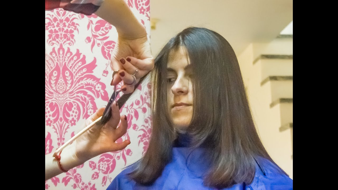 Cutting dry long hair in a young brunette