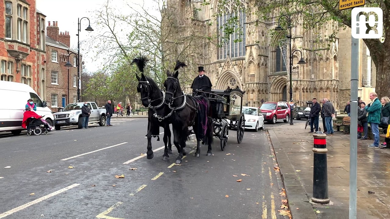 Horse drawn funeral procession for Brian