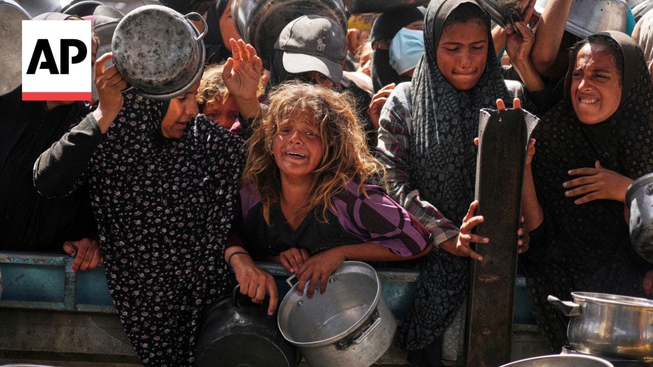 People surge forward to get food at a charity kitchen in Gaza