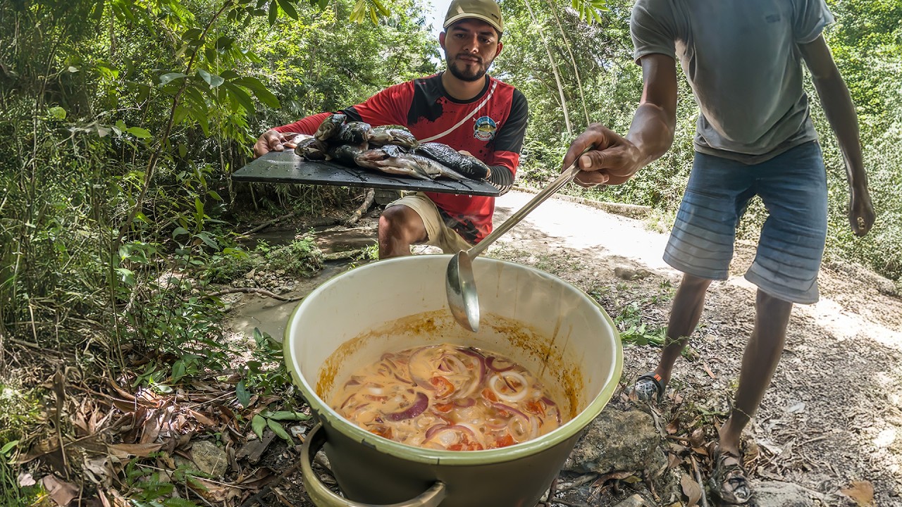 Pescando y cocinando en caldo muchas tilapias con arpón en corrientes que salen del rio