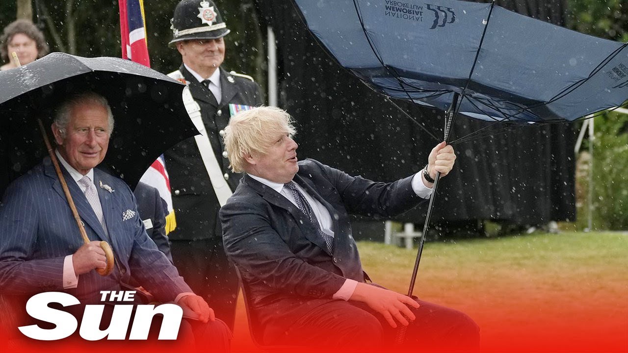 Boris Johnson struggles with umbrella at police memorial