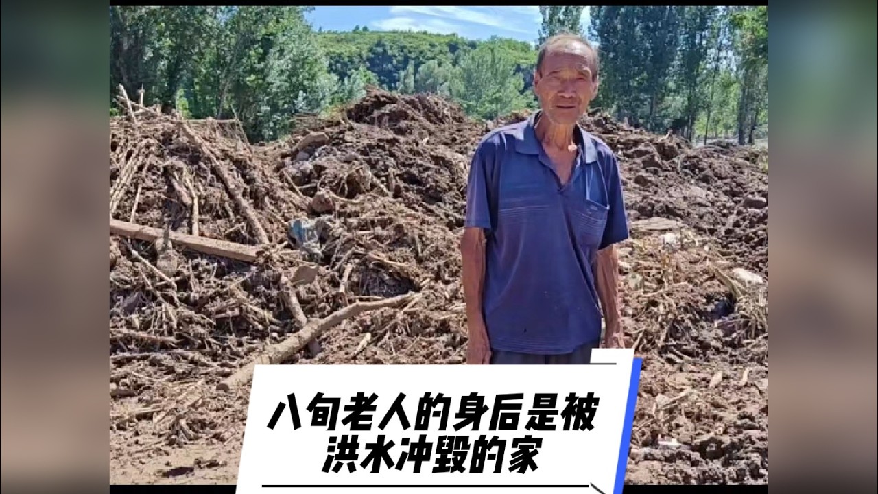 八旬老人的身后是被洪水冲毁的家
