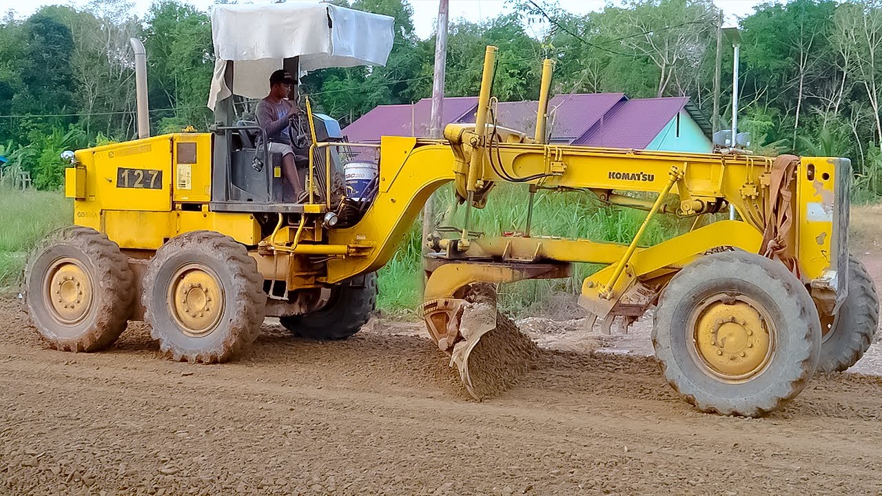 skill operator motor grader Komatsu Menghampar Rata Batu Split di Jalan
