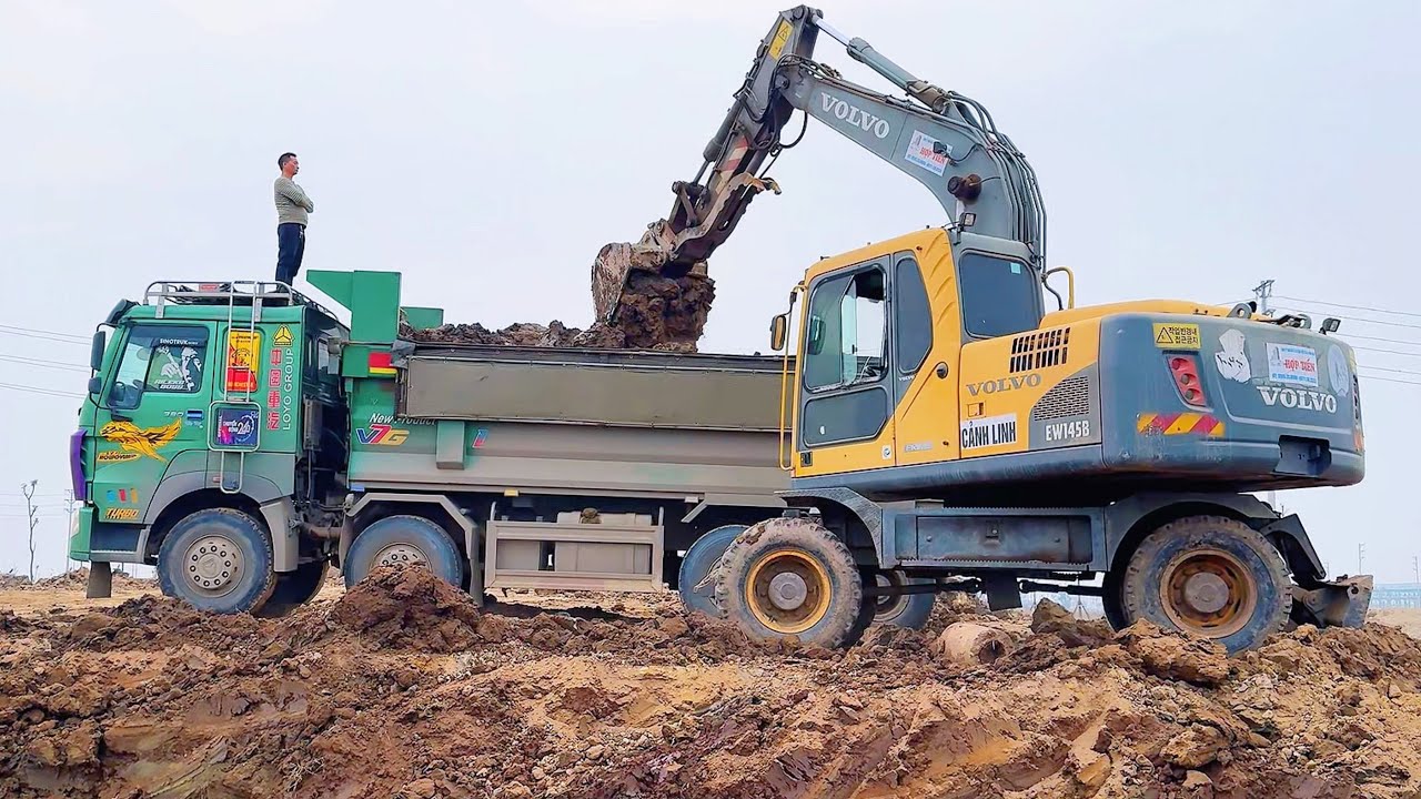 M&aacute;y x&uacute;c m&uacute;c đất mạnh mẽ đổ đầy xe ben tại c&ocirc;ng trường x&acirc;y dựng - Excavator Truck