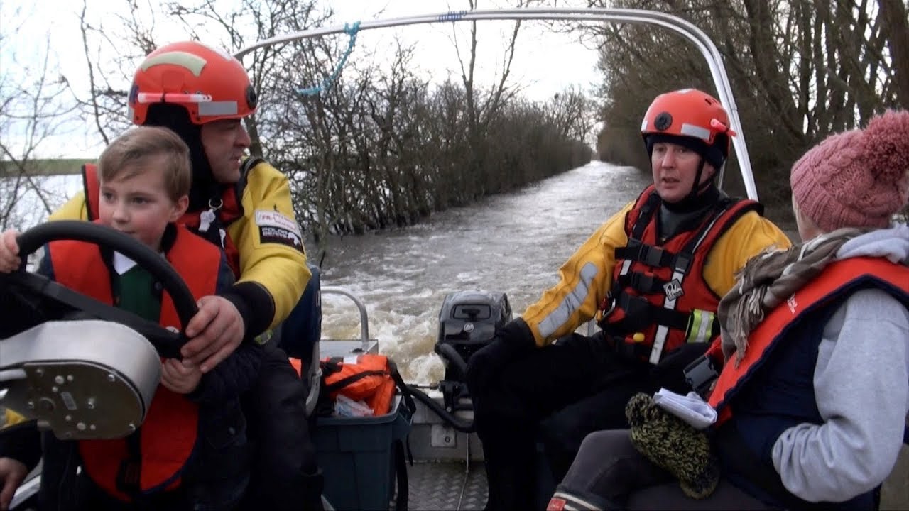 Fire Brigade Ferry Residents to Village Cut Off by Flood