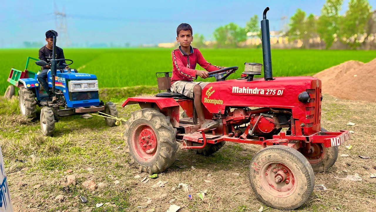 mini Sonalika tractor is stuck in the canal, and we are pulling it out with a mini Mahindra tractor
