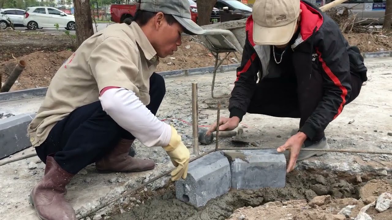 Construction workers pave the sidewalk for the park's walkways in the urban area