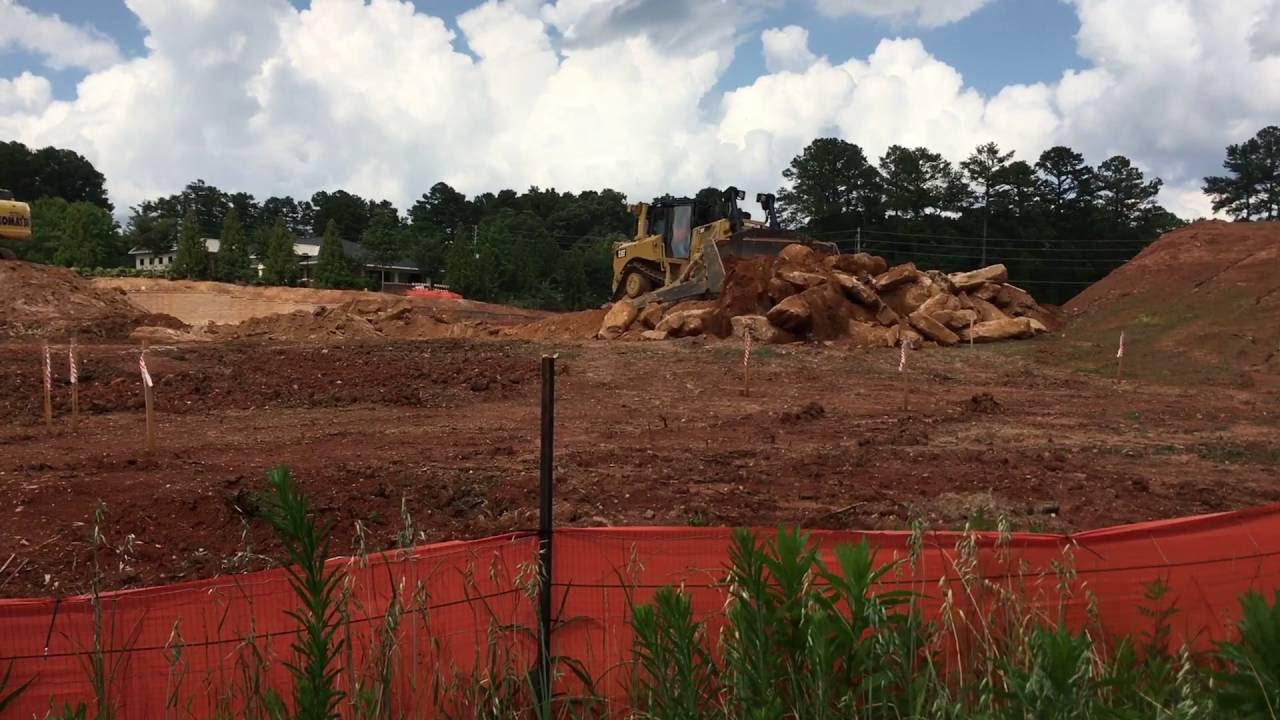 Cat D8T and Komatsu PC170 working with big rocks.