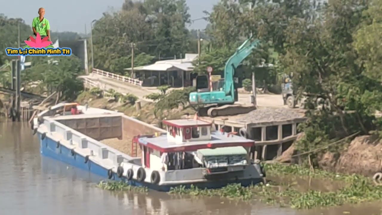 xà lan cập bến cho tê y bóc đá vận chuyển lên xe 