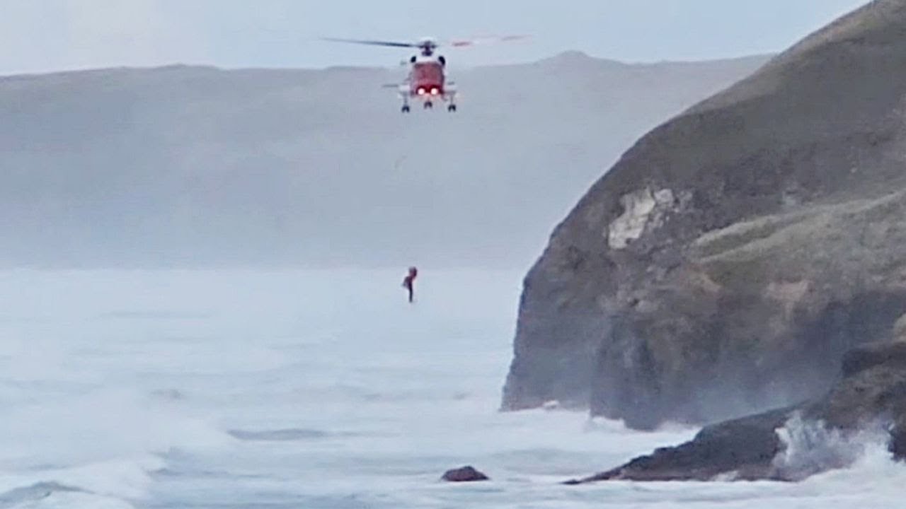 Video shows dramatic rescue after dog walker falls into the sea | SWNS