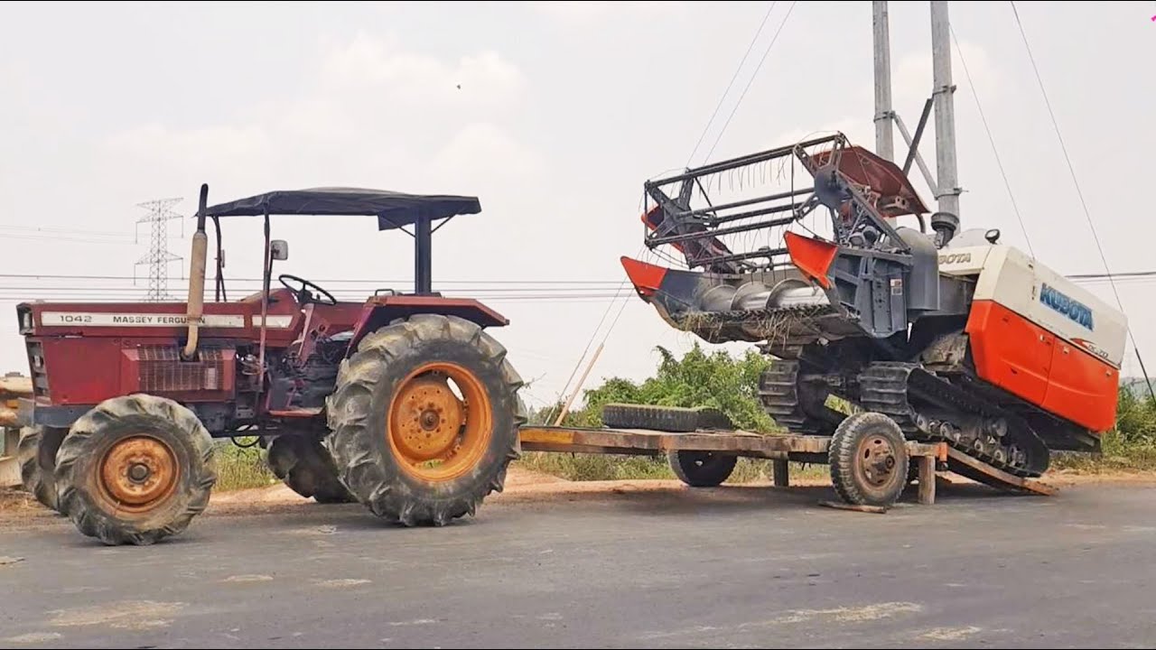Cận cảnh máy cày Hiếm MF 1042 chở máy cắt lúa Kubota DC70 chạy trên đường ở miền đông |  tractor