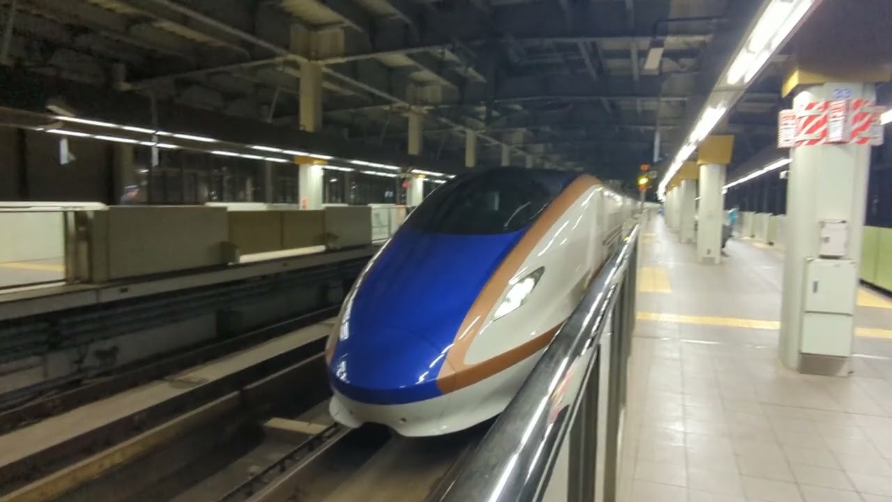 2026年2月21日北陸新幹線金沢(駅)各停車中→発車·W7系W編成運行 12番のりばW1編成(回送列車)回送2295E 13番のりばW12編成573Eはくたか573号→(回送列車)回送573E