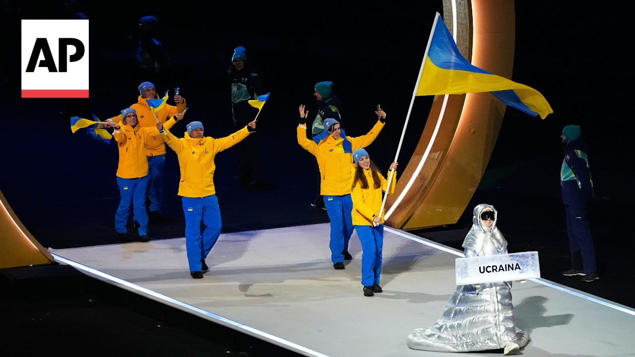 Russian woman carries Ukraine placard at Winter Olympics opening ceremony