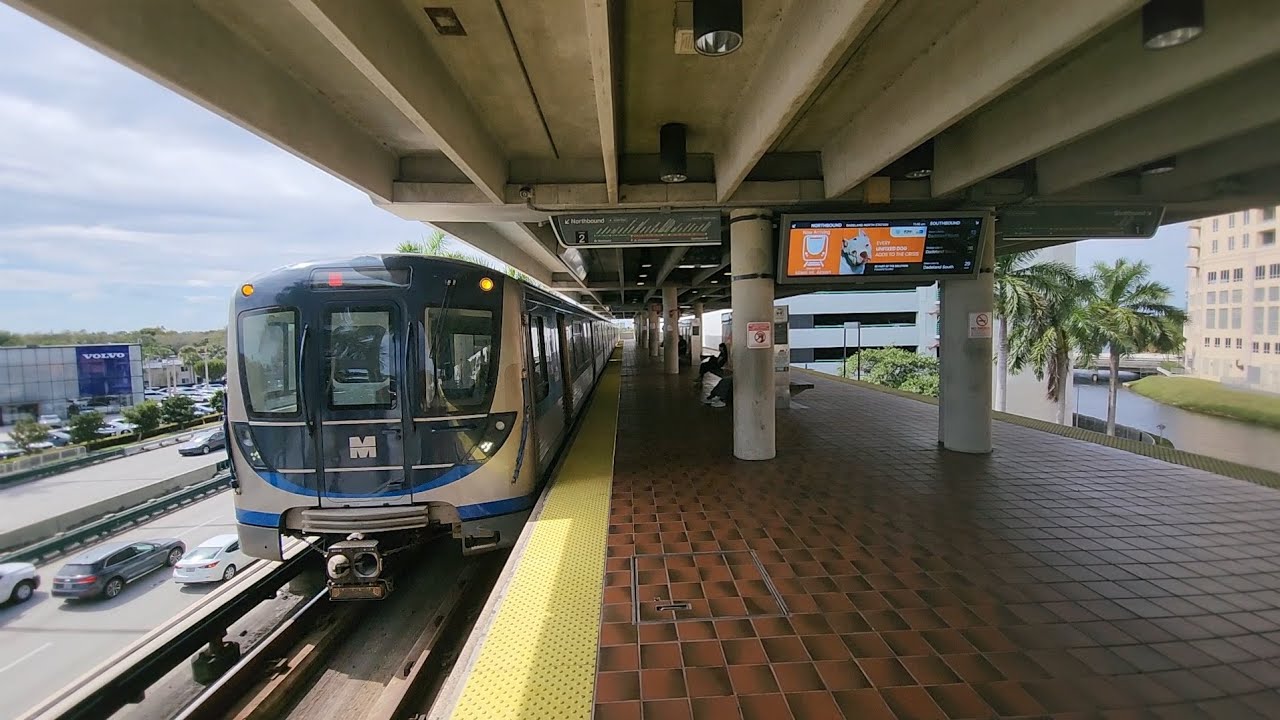 Miami Metrorail Northbound Orange Line train arriving and departing at Dadeland North Station. 