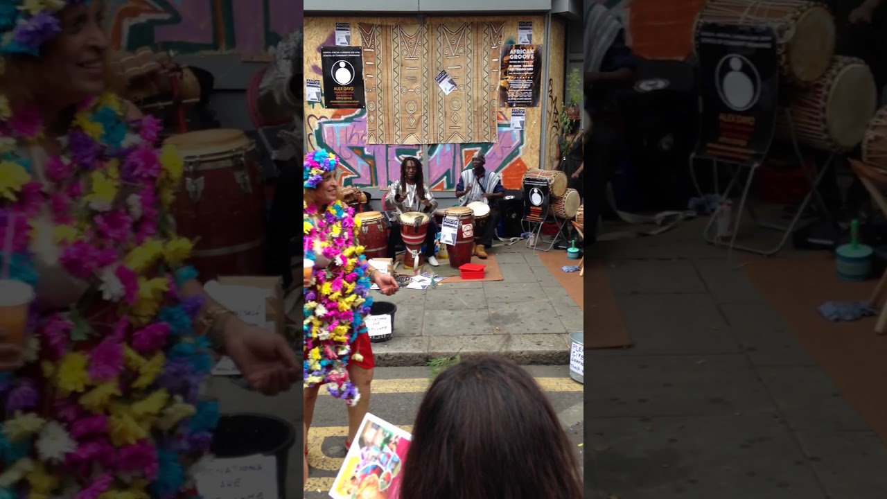 WOMAN DANCES WITH AFRICAN DRUMMERS AT NOTTING HILL CARNIVAL 2015