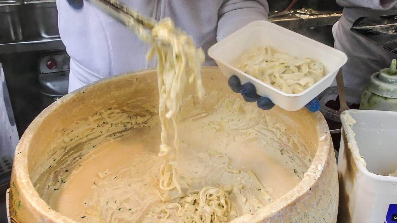 Hand Rolled Pasta Drowned in Melted Cheese Wheel. Street Food of Camden Lock market, London