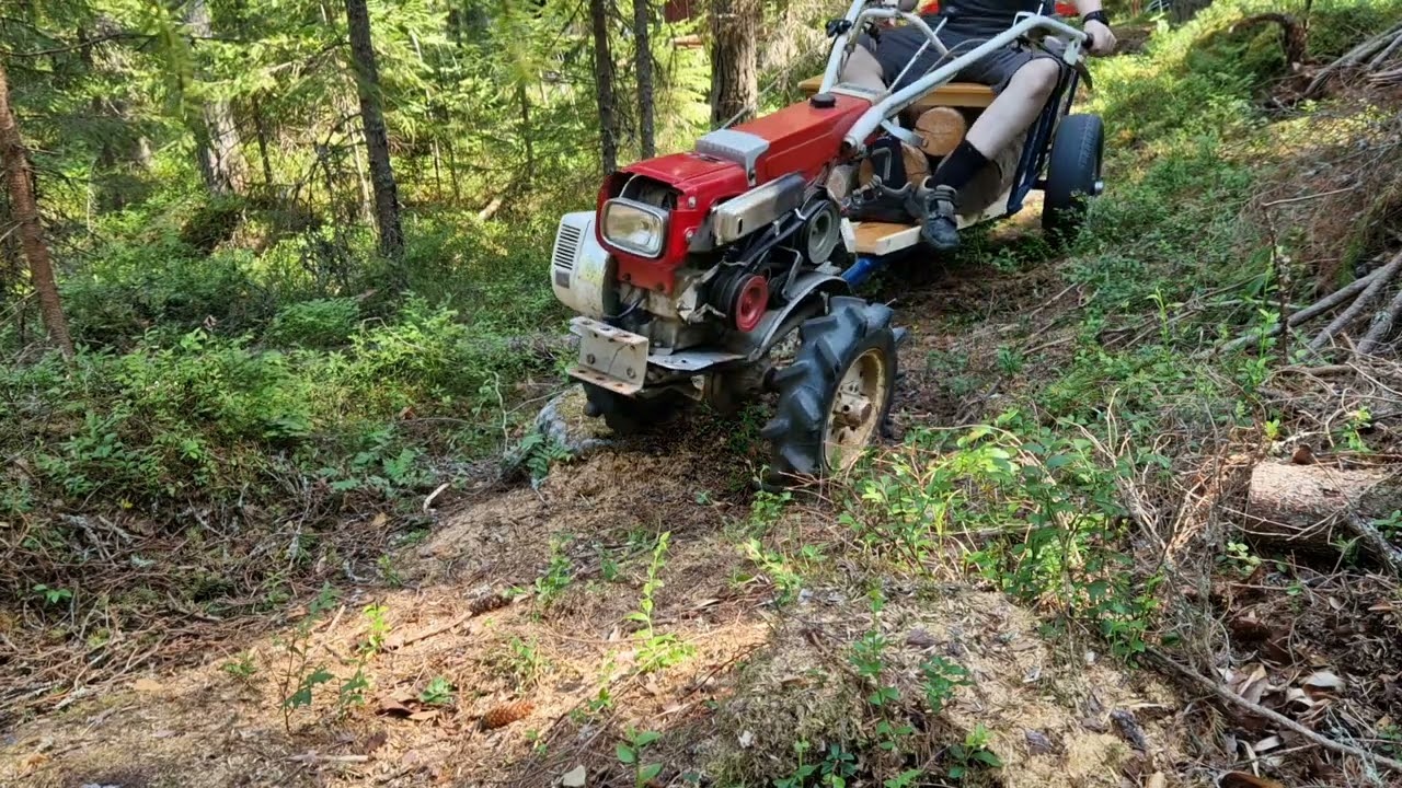 Mitsubishi CT351 two wheel tractor in forest with 150kg of wood on trailer.