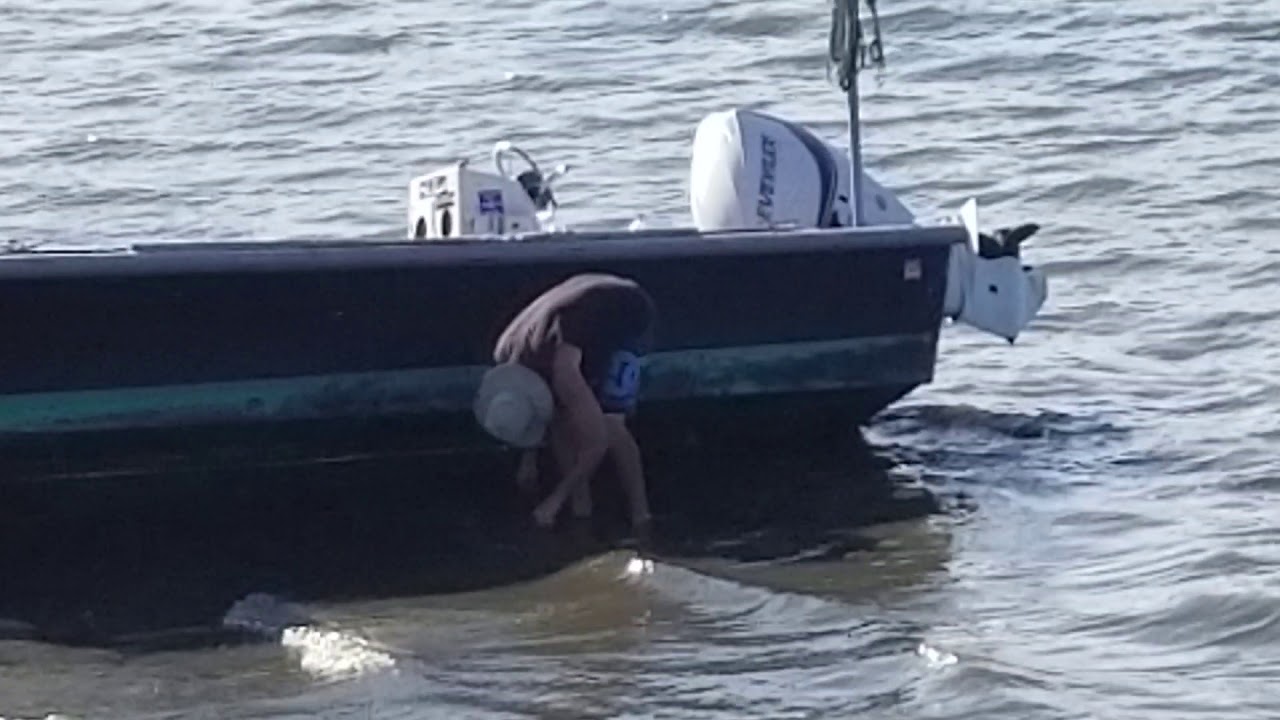 MAN SCRAPING BOAT - OYSTER BAY, NEW YORK