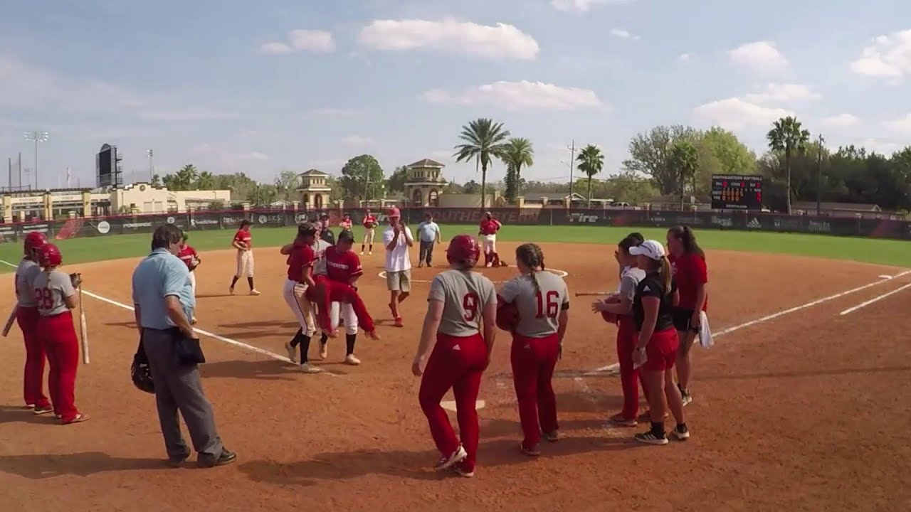 Softball players carry injured opponent around bases