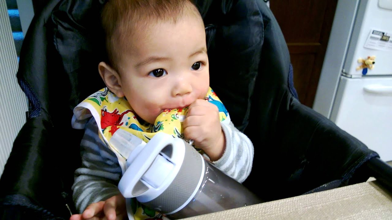 Timothy likes his bib more than the big sippy bottle
