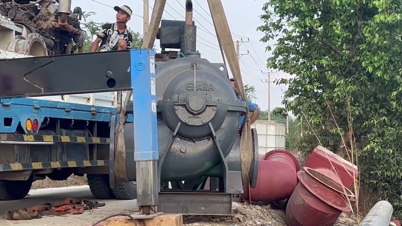 Lifting machinery (large-scale water pumps) to fill a large water hole in a suburban area
