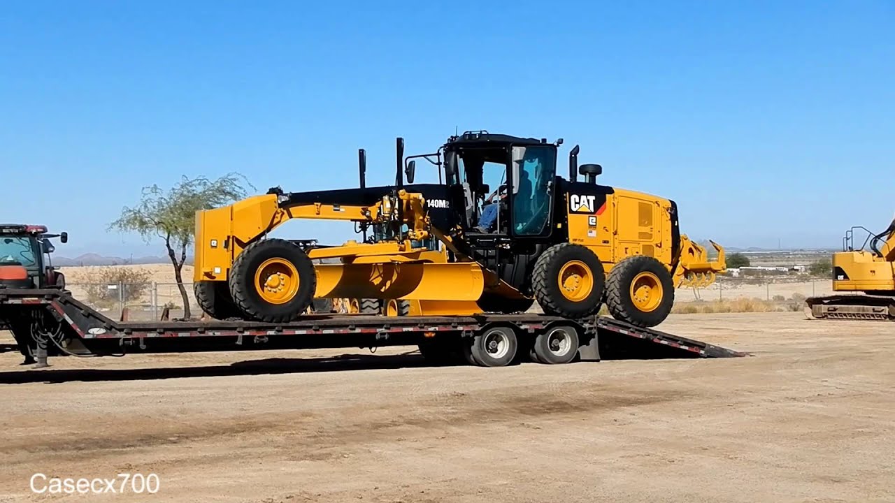 Unloading a NEW CAT 140M SERIES 2 GRADER