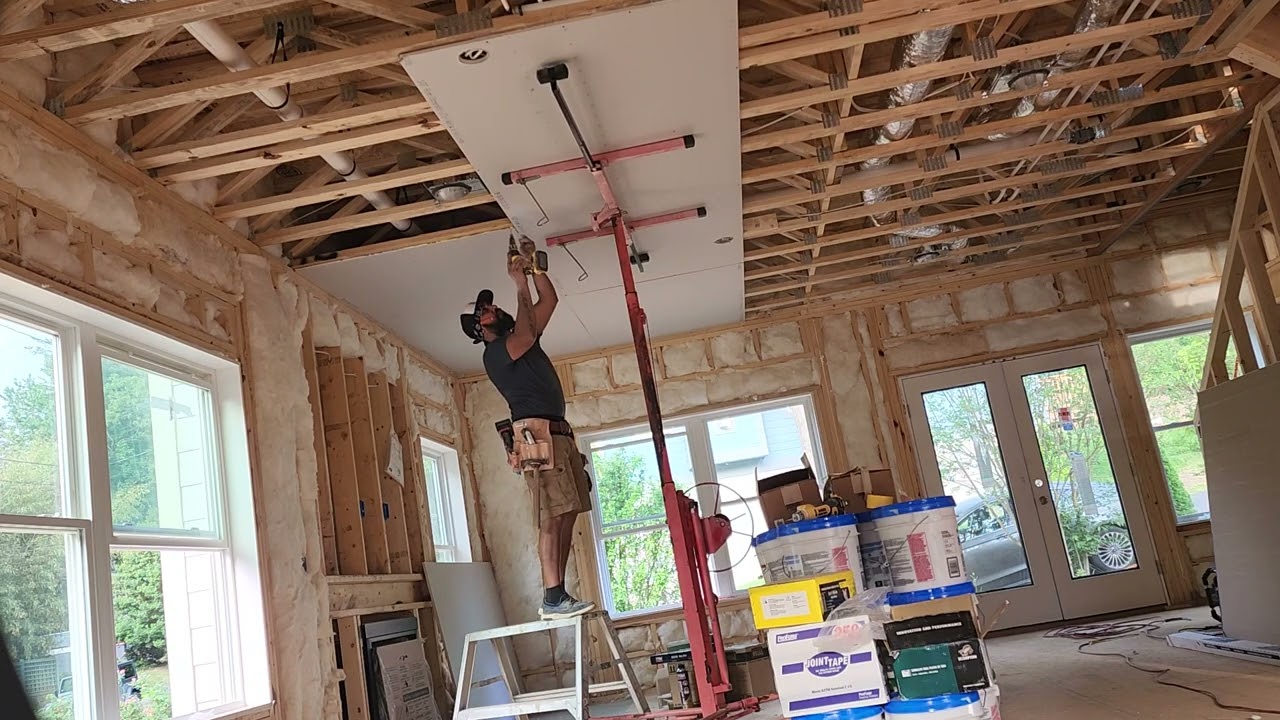 hanging drywall on ceiling with a drywall lift