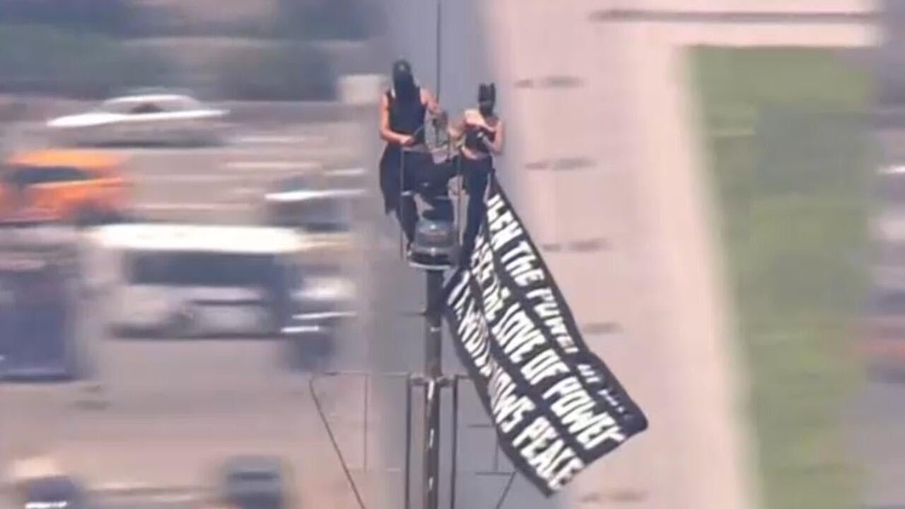 2 people climb to top of Empire State Building and fly banner