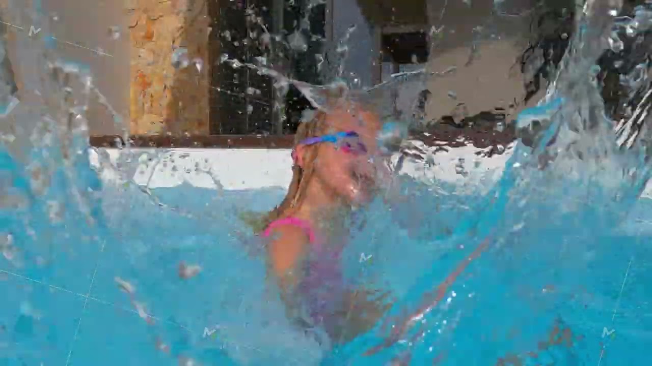 Girl playfully splashing pool water