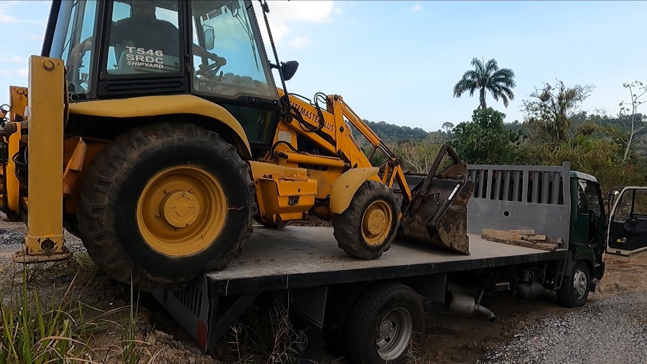 Loading & Offloading a backhoe on a Flatbed Truck | Rousillac South - San Juan