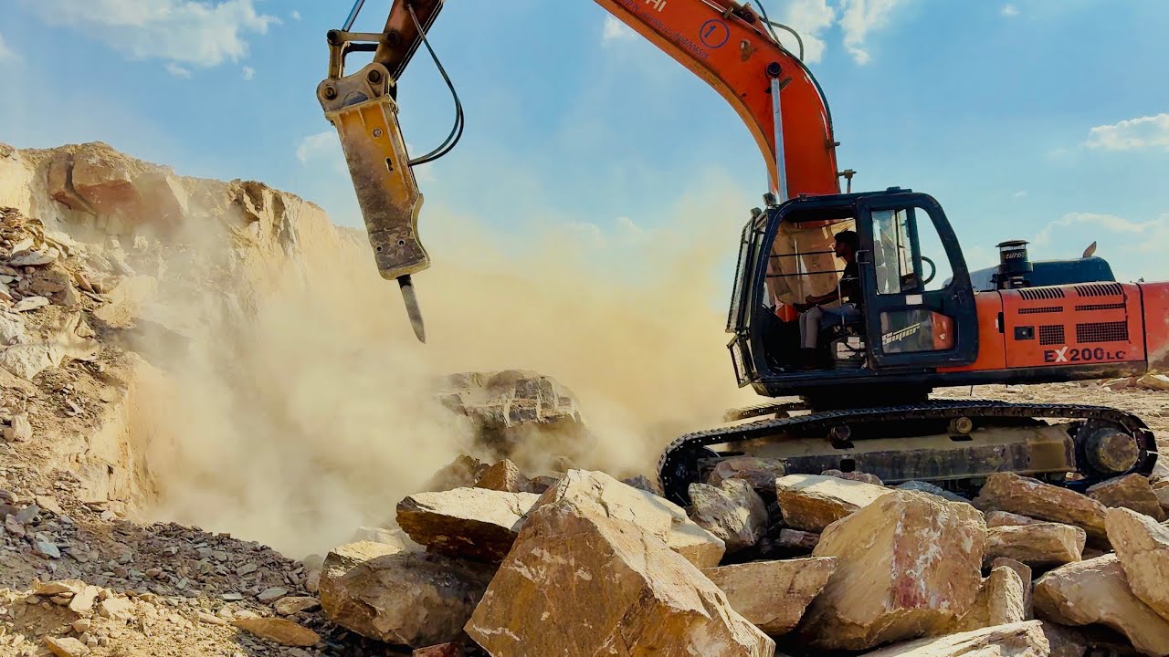 Breaking rocks with an excavator