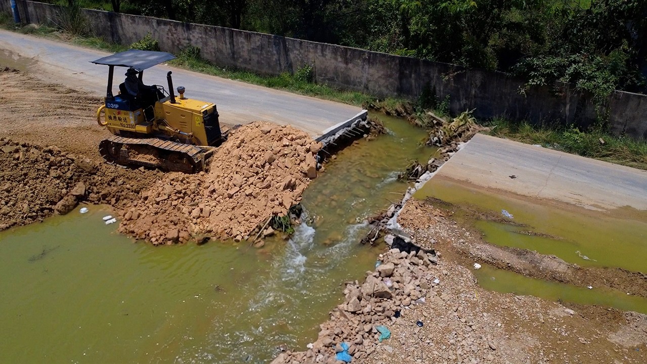 No skill driver dozer D31 pushing stone delete flooded land to connect wall with dump truck 25.5Ton