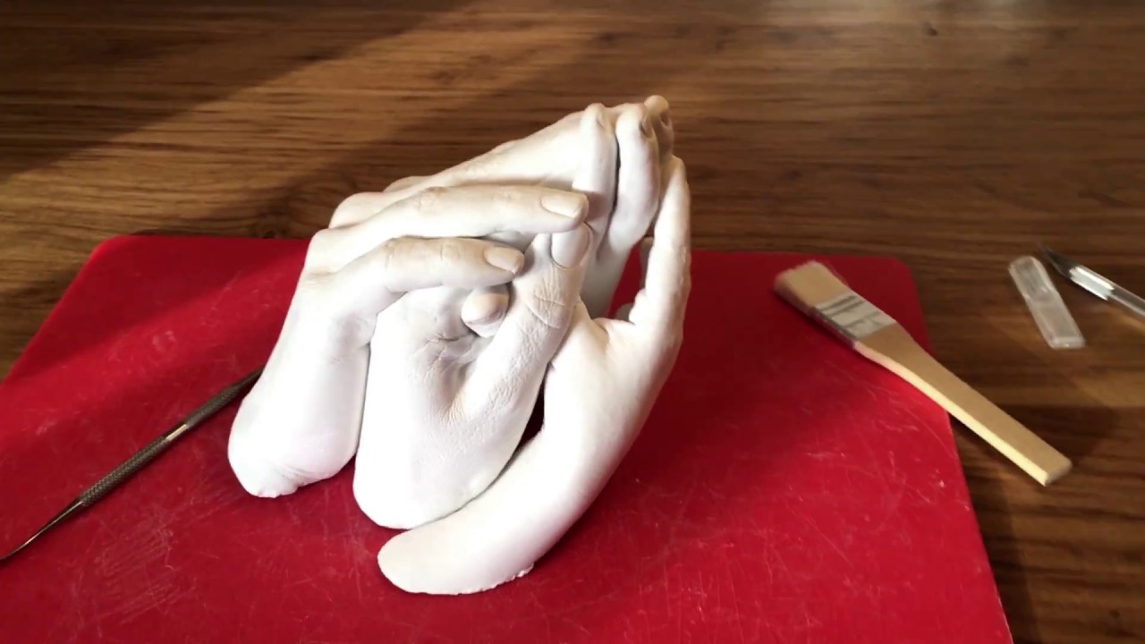 Le moulage famille, les mains enlacées.