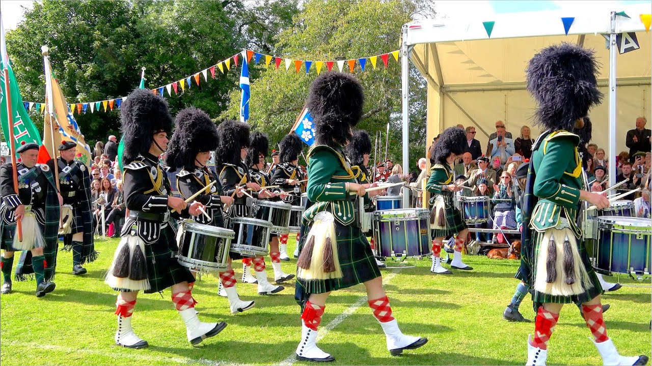 Pipe Bands lead the Lonach Highlanders march into 2024 Lonach Gathering & Games in Scotland