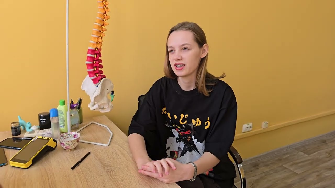 Стройная девушка со сколиозом на приеме у мануального терапевта.