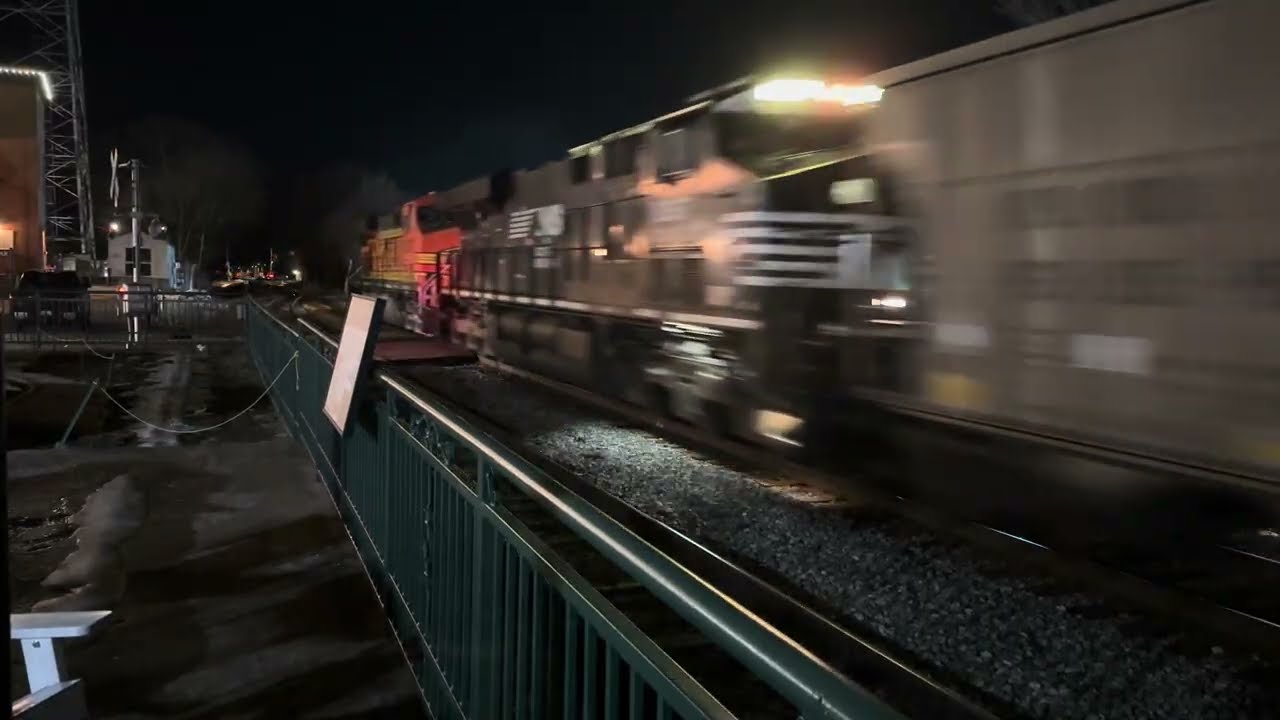 BNSF coal train in Collierville, Tennessee at night with a Norfolk Southern DPU