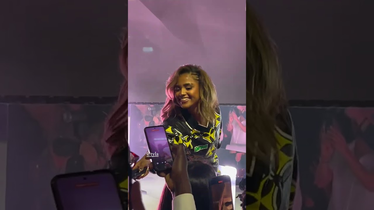 Tyla gives a fan the mic during her &ldquo;Water&rdquo; performance at the Prelude To The Olympics 2024