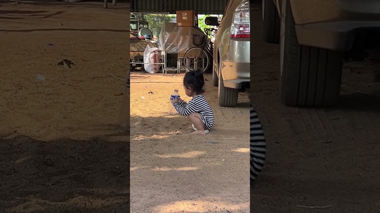 After waking up from sleep, the baby plays in the sand.
