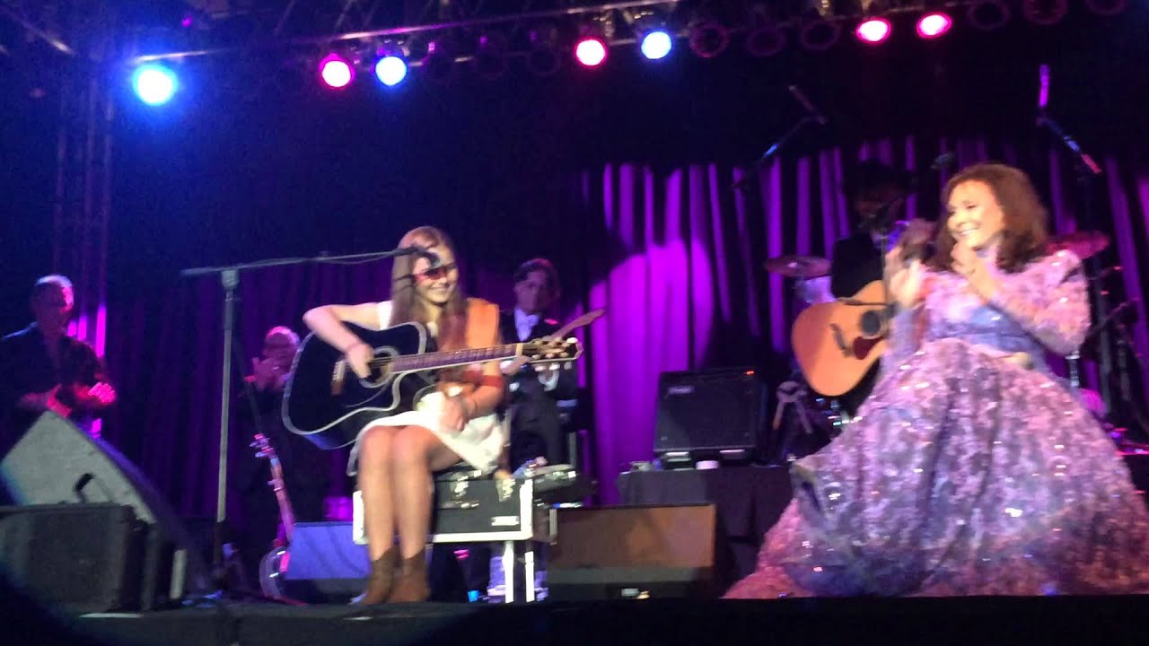Loretta Lynn's granddaughter performs onstage while she watches with a smile. Delta Downs 3-21-