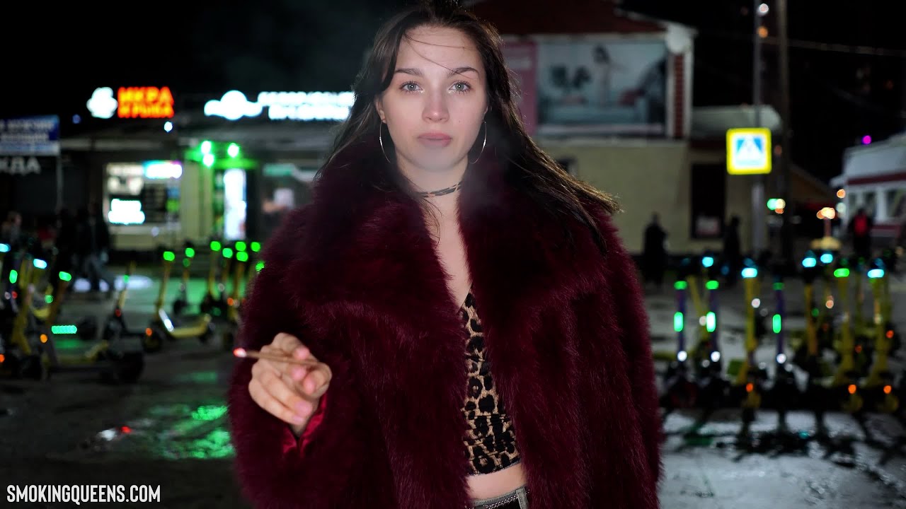 Tina is smoking More 120s cigarette in a fur coat on the street 4K resolution