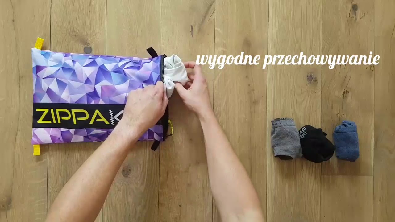 Fioletowa saszetka Zippak pomaga wygodnie przechowywać rzeczy w podr&oacute;ży.