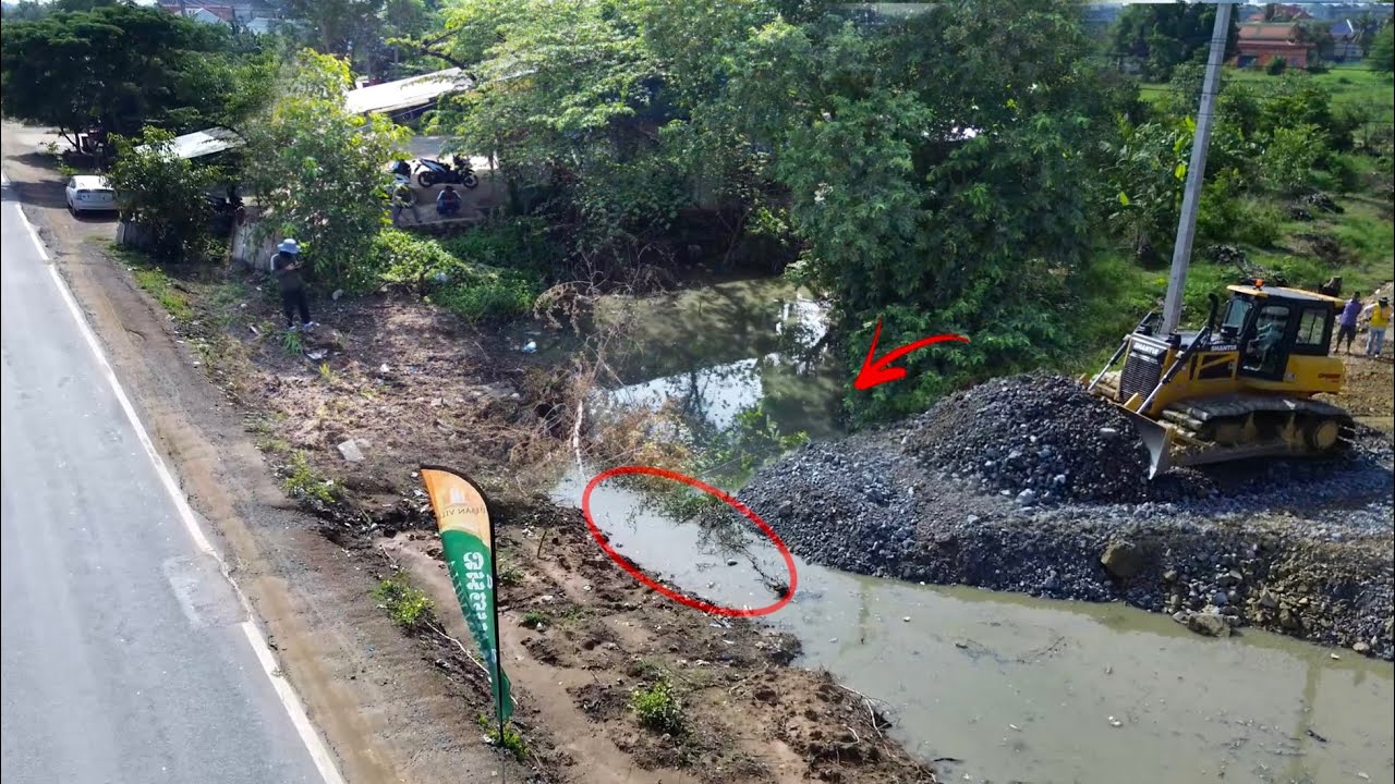 Operator SHANTUI Bulldozer Continues Moving Rock into Canal Make Dam Road and Fill the Rice field