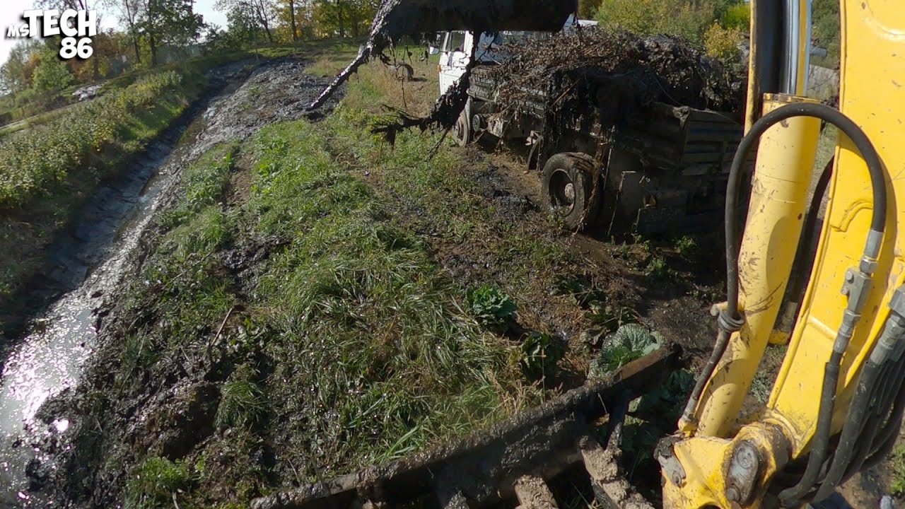 Desilting Dirty And Muddy Drainage Ditch With An Excavator