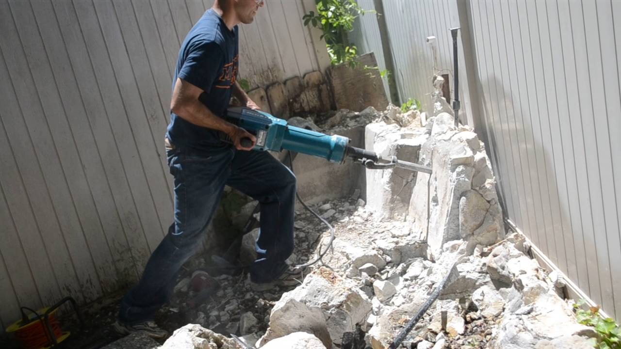 Using a jack hammer to remove a koi pond and water feature