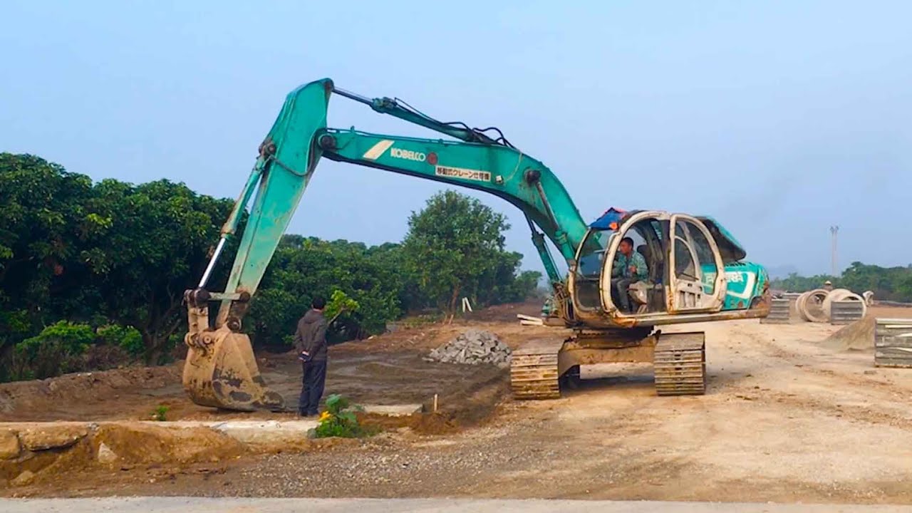 Launching a new project, KOBELCO scoops rocks. Synthesis of excavators, road rollers, dump trucks
